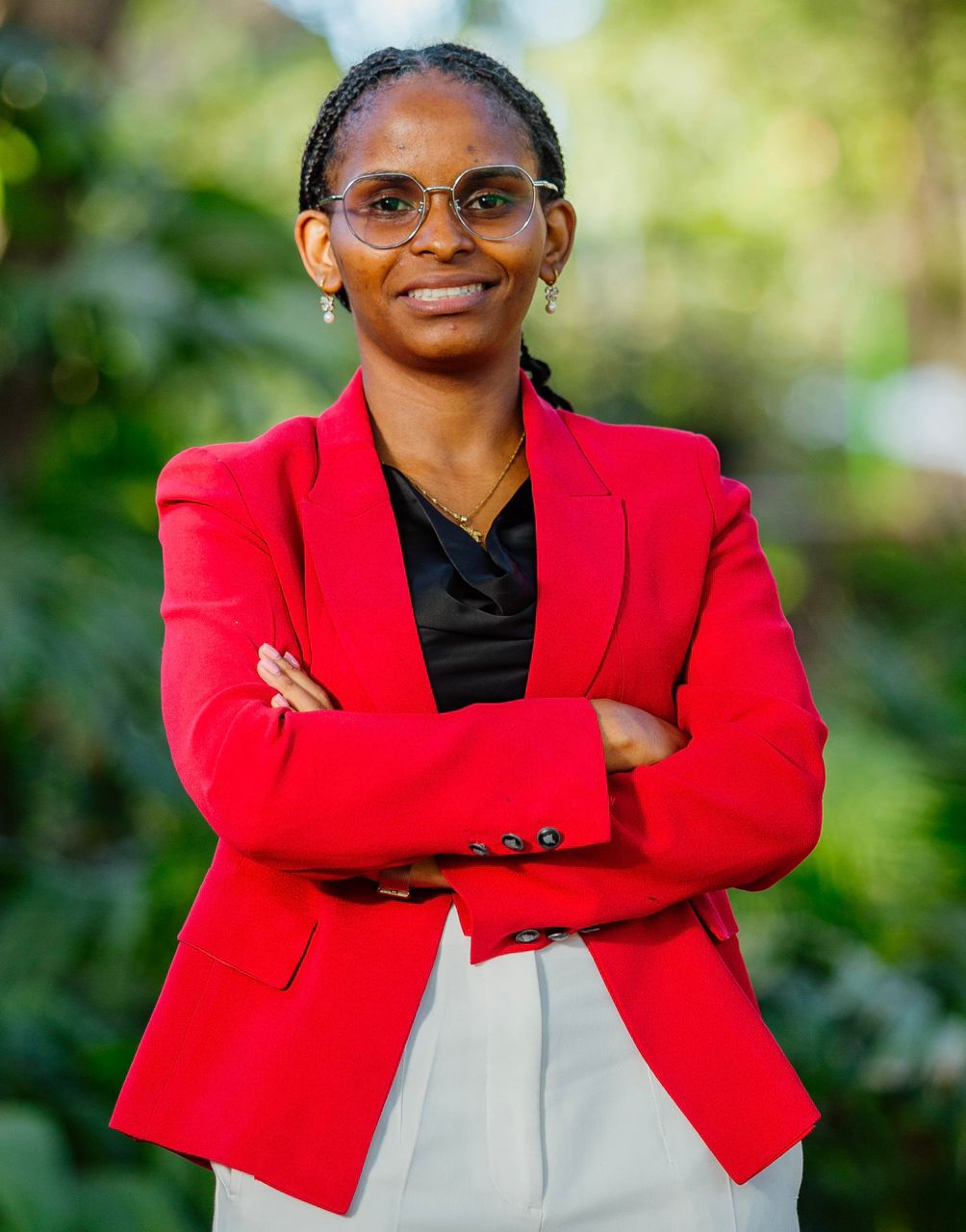 Jackline Ngowi standing in a red blazer with her arms crossed.