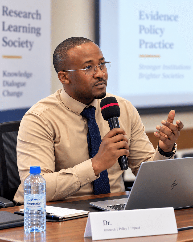 Davis Amani speaking in an academic conference setting.